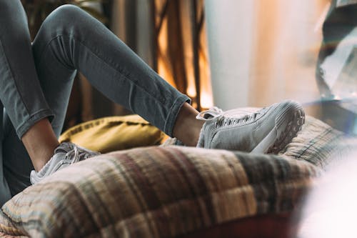 A person in Grey Skinny Denim Jeans and Grey Sneakers