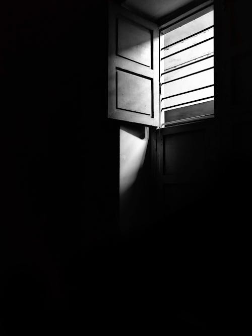 Фотография открытого окна в оттенках серого
