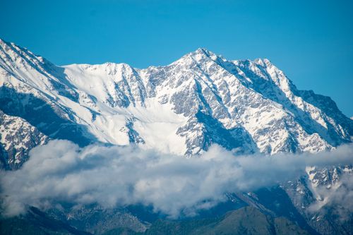 Free Stunning view of a snow-capped mountain range standing tall under a clear blue sky. Stock Photo