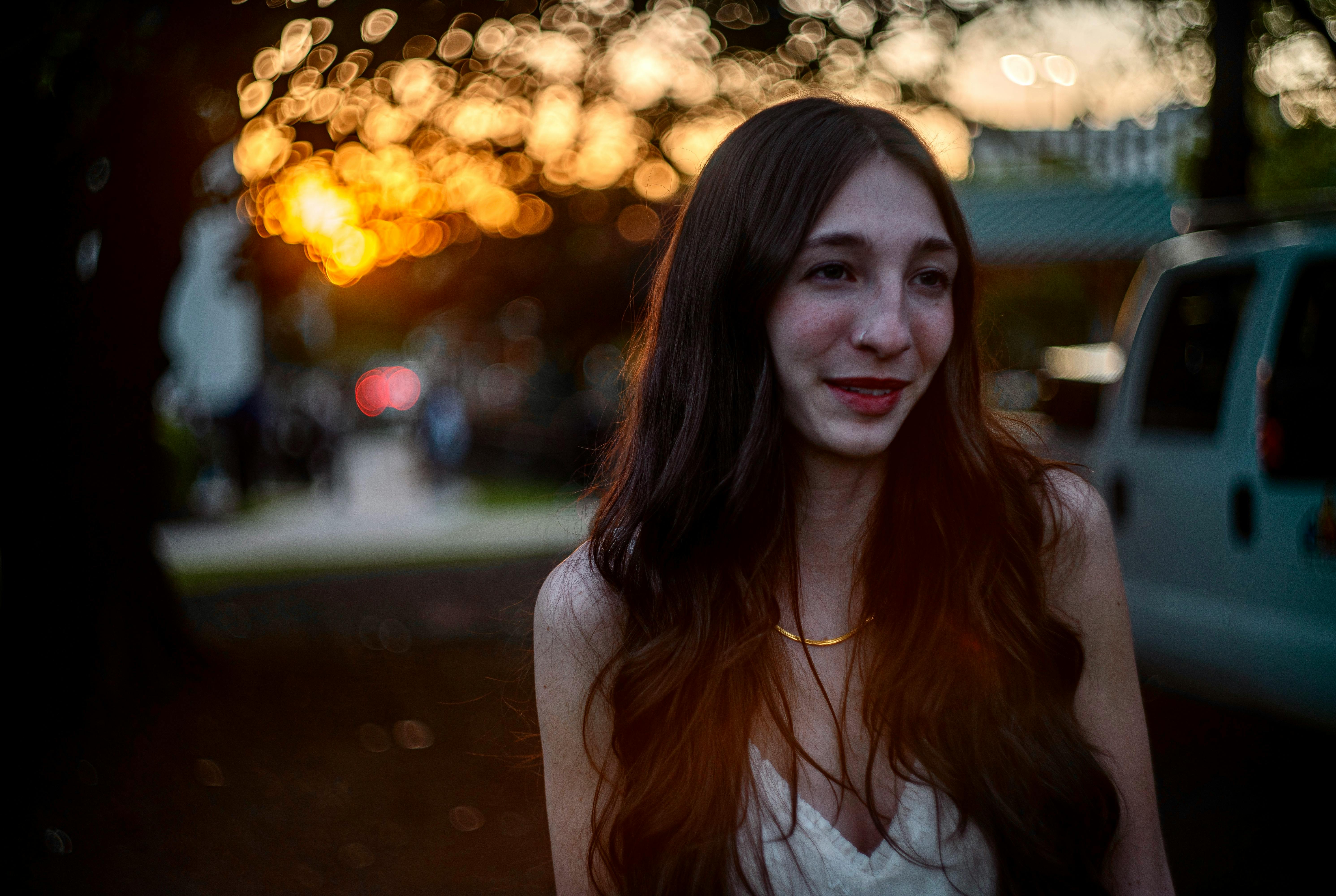 portrait of brunette woman on a street during sunset