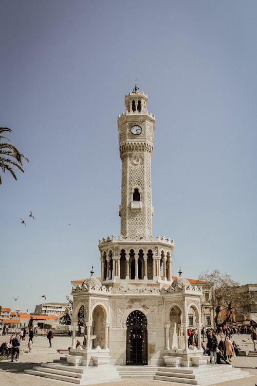A clock tower in the middle of a plaza