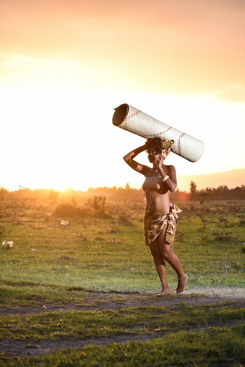 Mulher Em Pé Enquanto Carrega Um Rolo De Papelão Branco