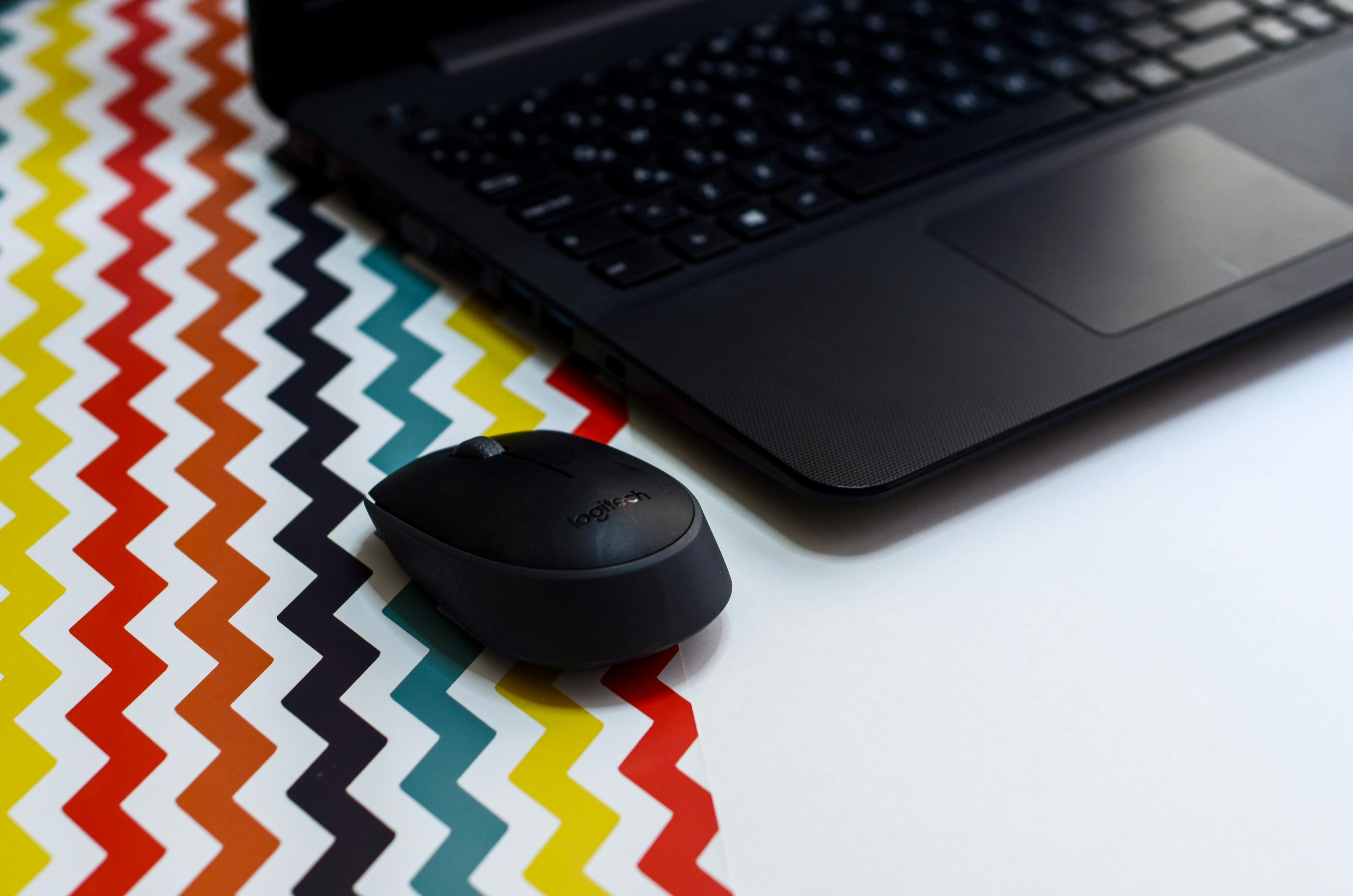 Black Wireless Mouse Beside Laptop