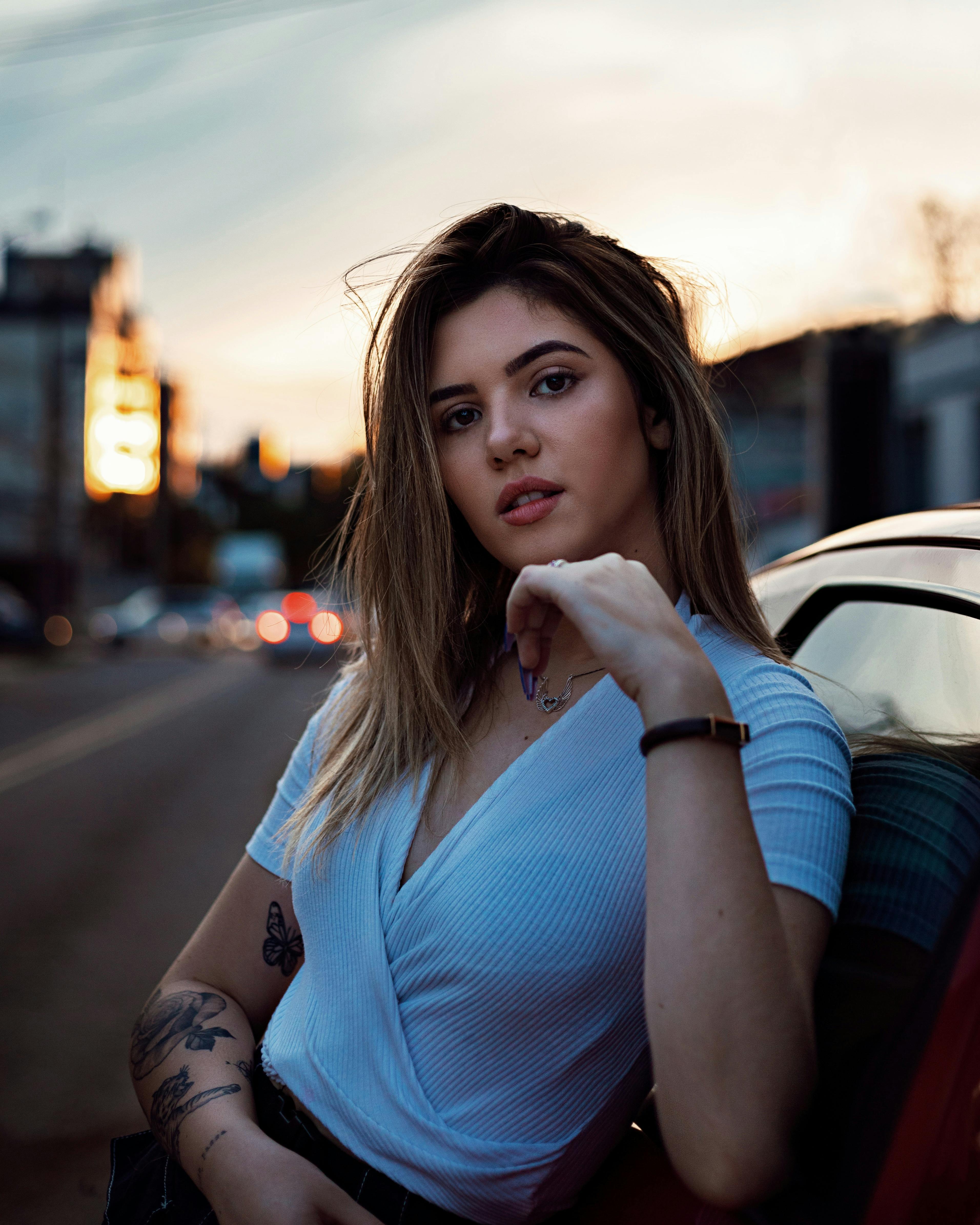 close up photo of woman leaning on vehicle posing