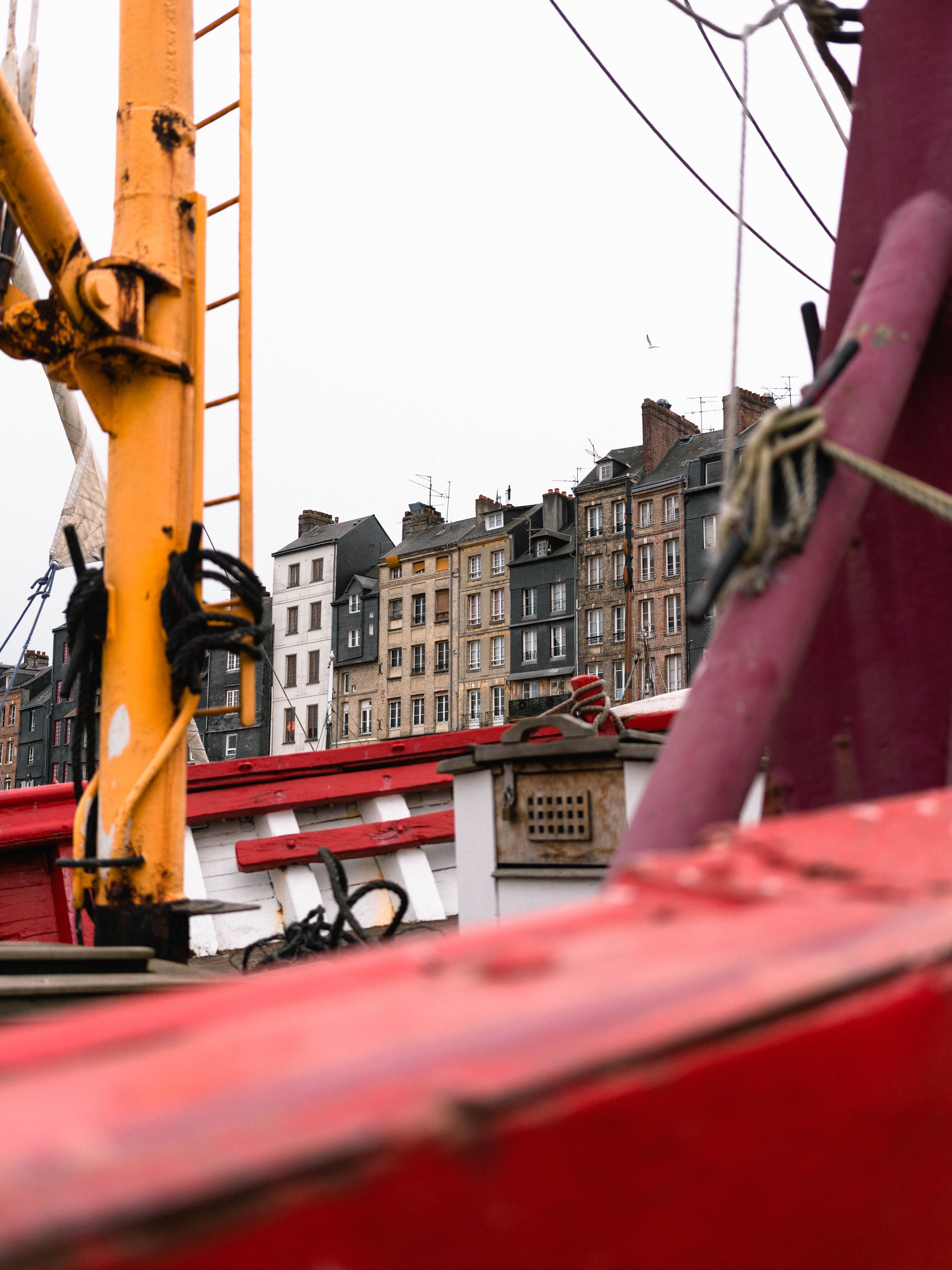 Vibrant boats against historic buildings in Honfleur, France, showcasing a picturesque harbor scene.