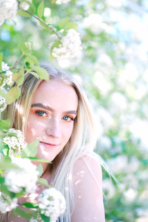 Woman Standing Beside White Cluster Of Flowers