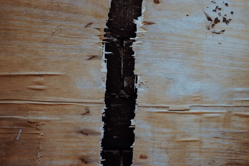 Texture de bois fendu avec fissure profonde dans une poutre ancienne — traitement xylophages en Normandie