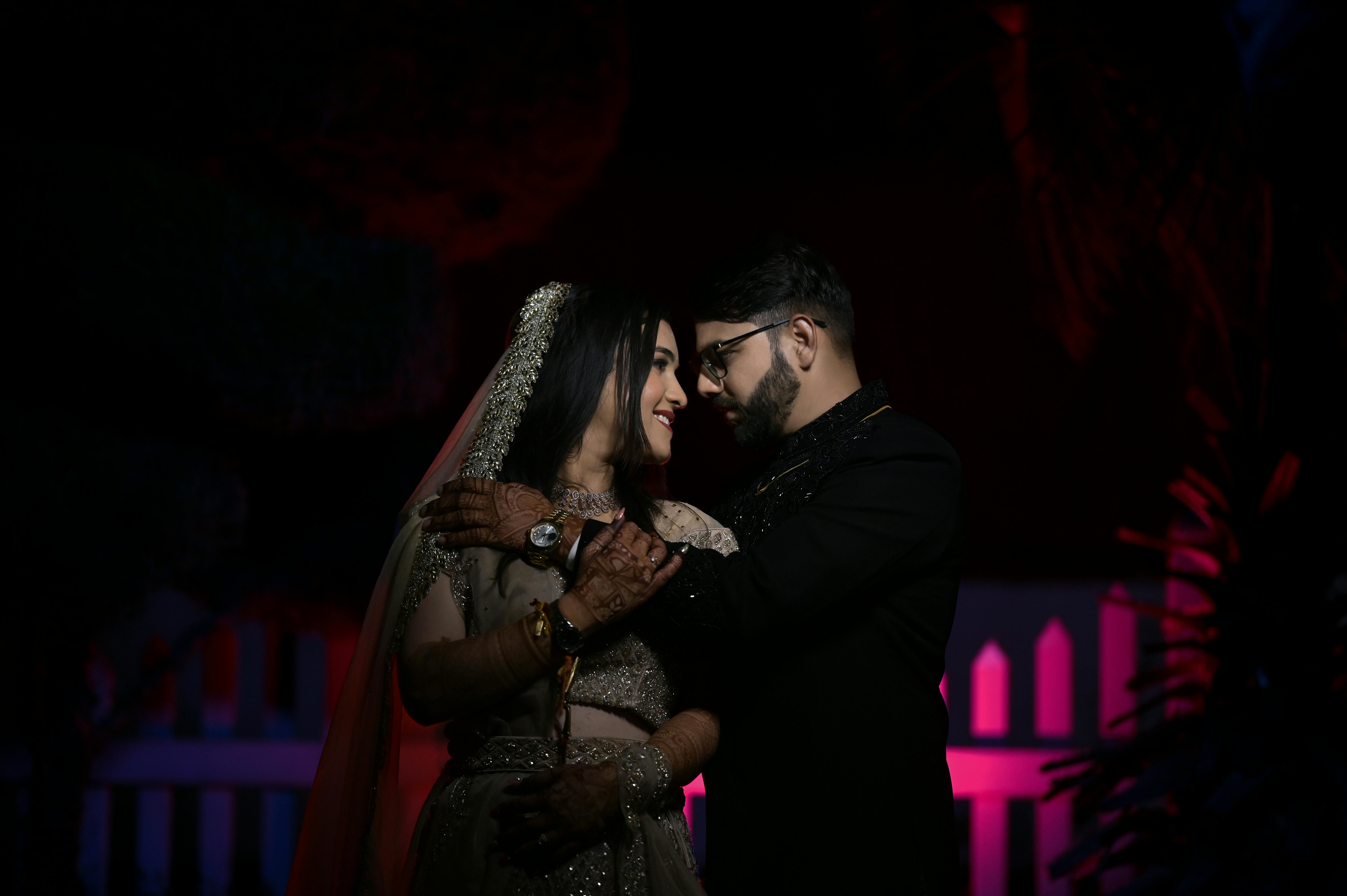 A beautiful couple embracing in a romantic wedding setting, captured in low light.