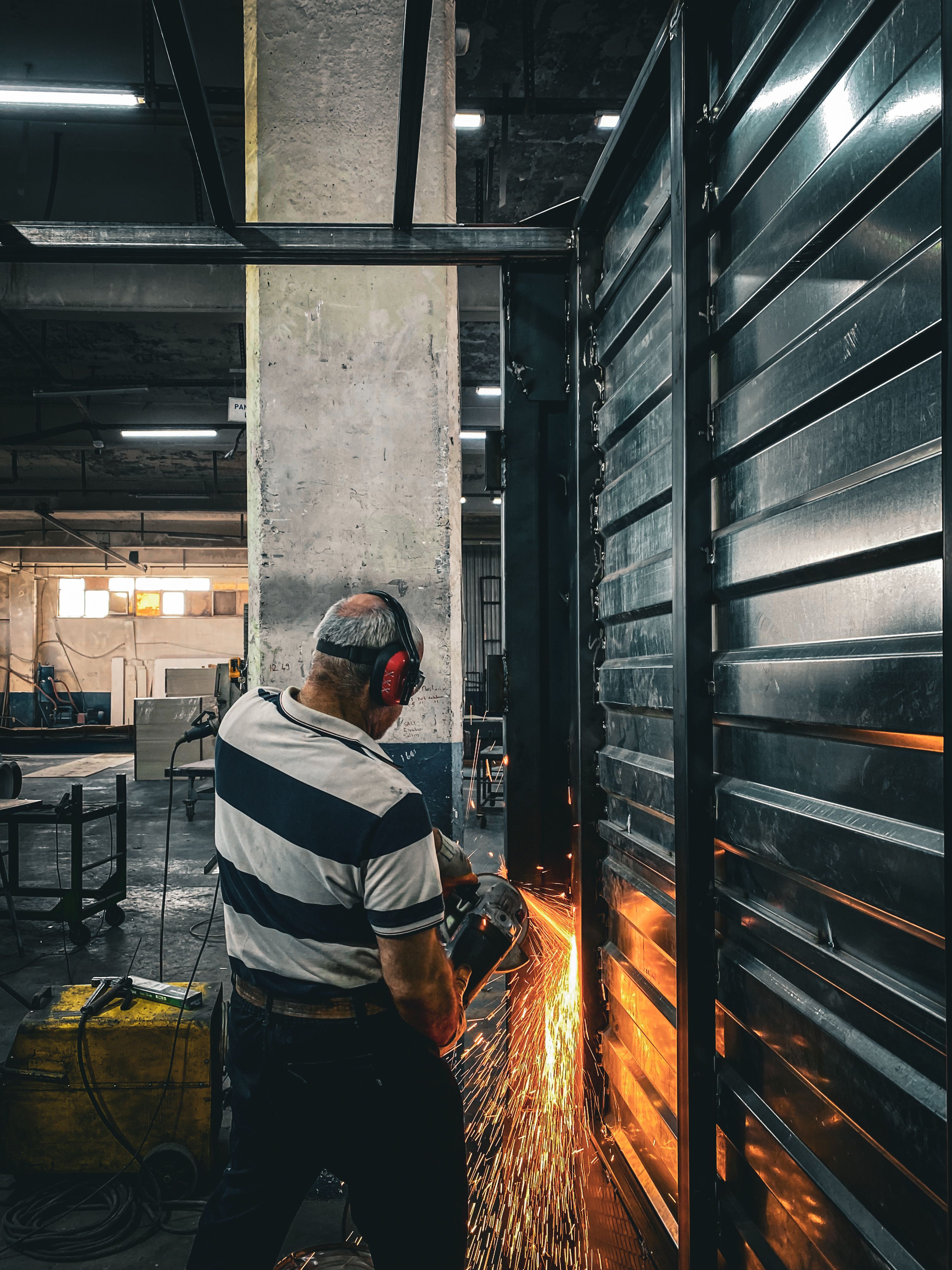 Sparks flying from an angle grinder cutting steel in a fabrication shop