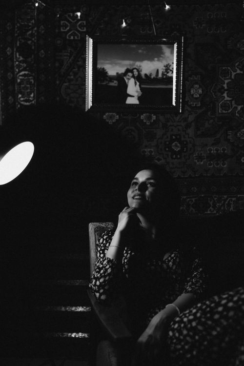Free Artistic black and white photo of a woman sitting in a dimly lit room, exuding a reflective mood. Stock Photo