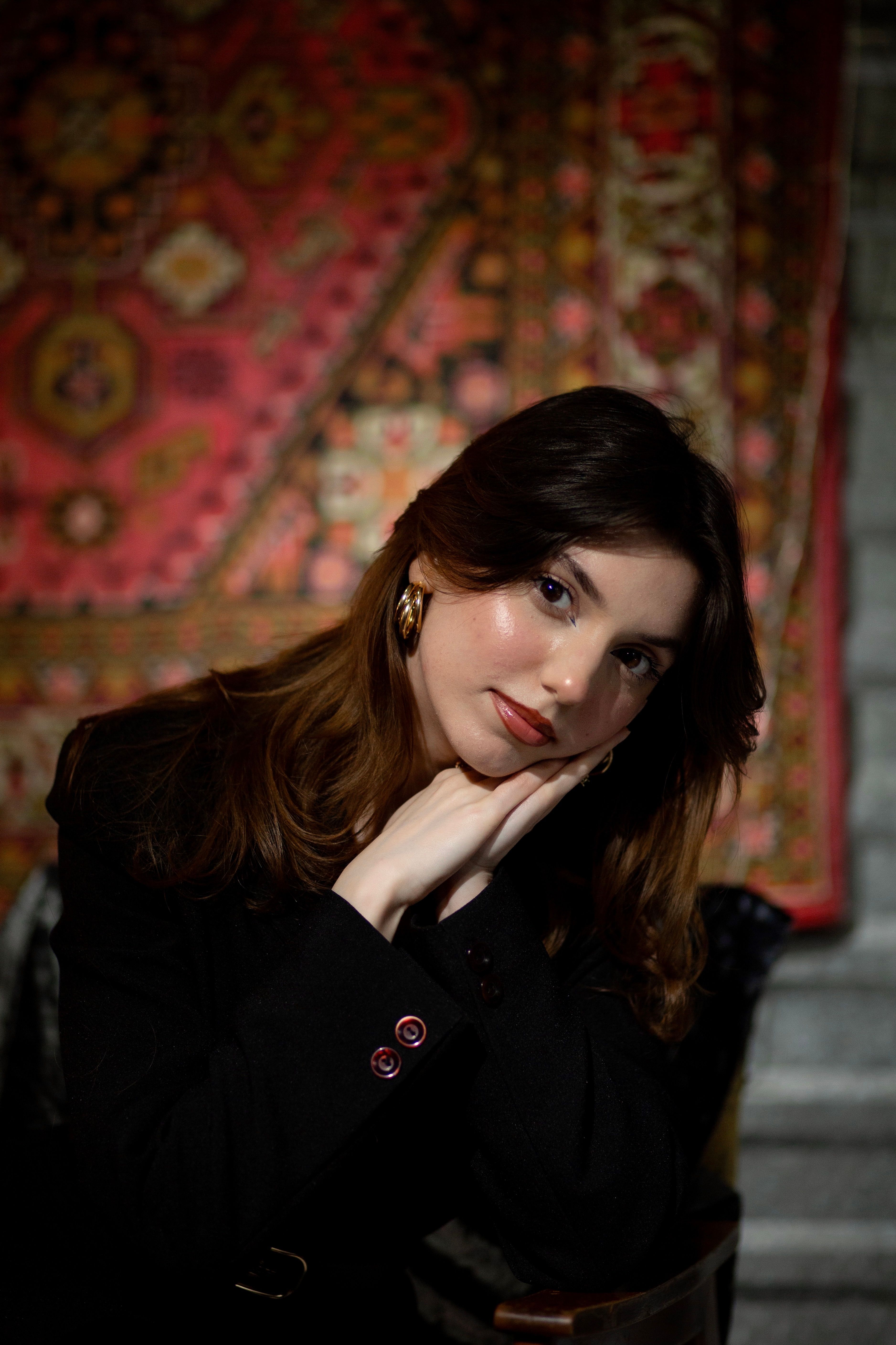 Artistic portrait of a woman posing with her hands on her cheek, showcasing elegance and style.