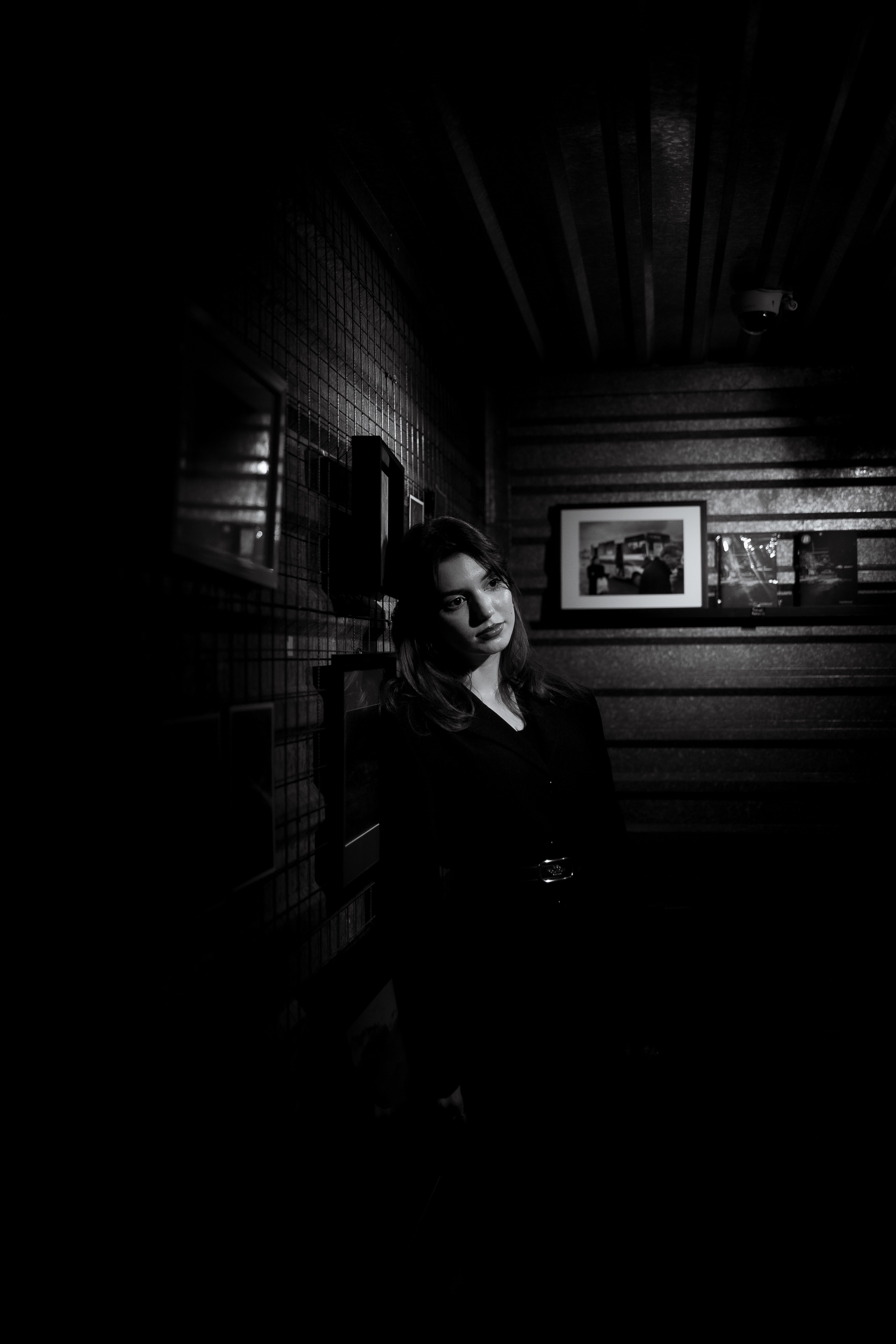 A woman in black and white is standing in a dark room · Free Stock Photo