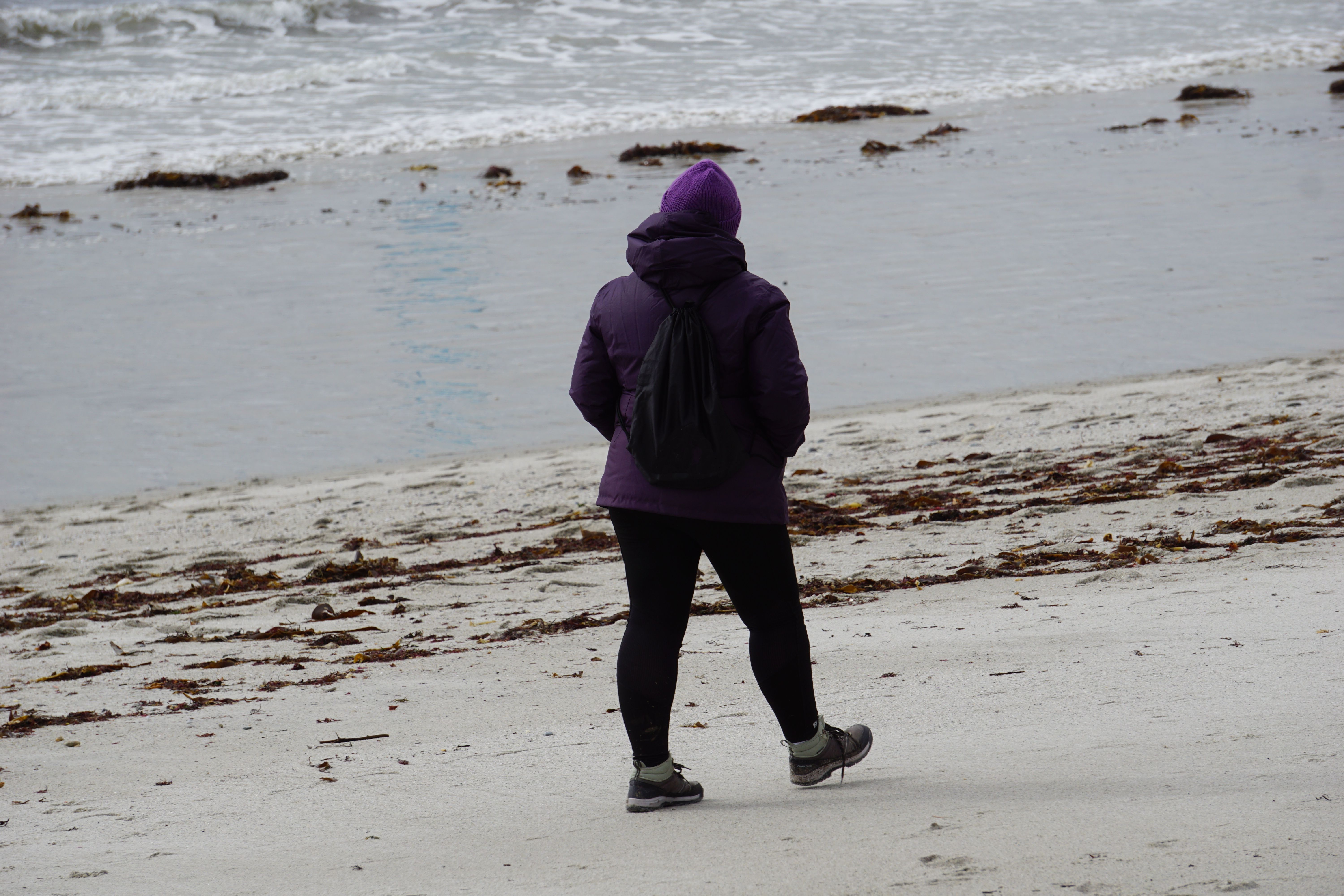 Woman in Jacket Walking on Beach · Free Stock Photo
