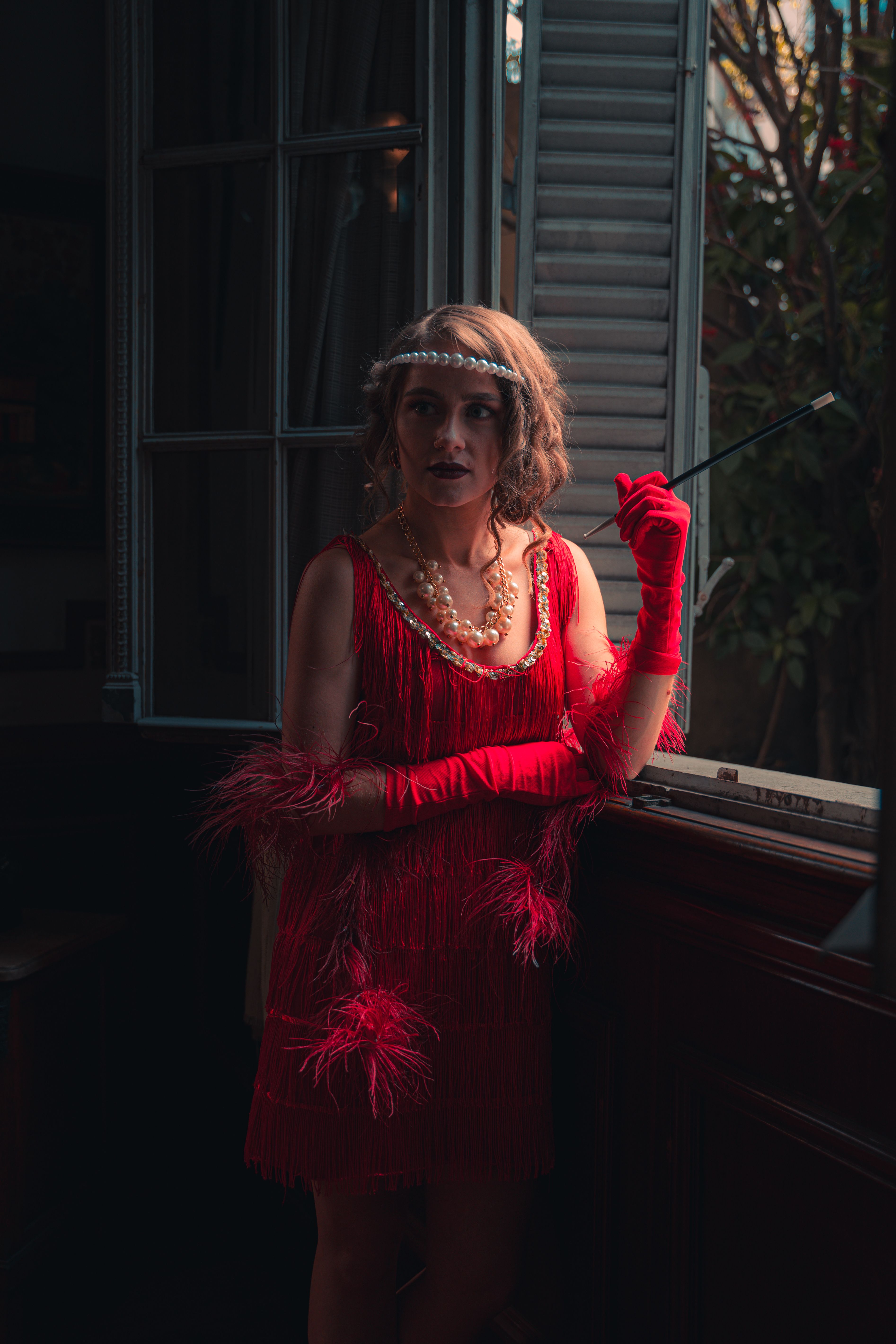Woman in Red Flapper Dress with a Cigarette on a Telescopic Smoking Pipe   Free Stock Photo