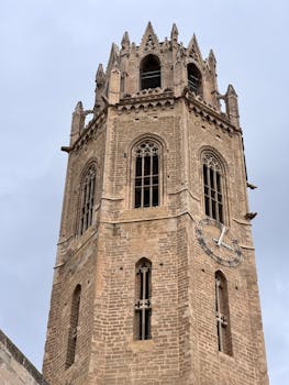 Impressive vertical shot of La Seu Vella's bell tower, a historic landmark in Lleida, Spain.