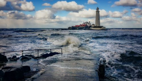 Free Dramatic view of St Mary's Lighthouse on a tidal island under a cloudy sky. Stock Photo