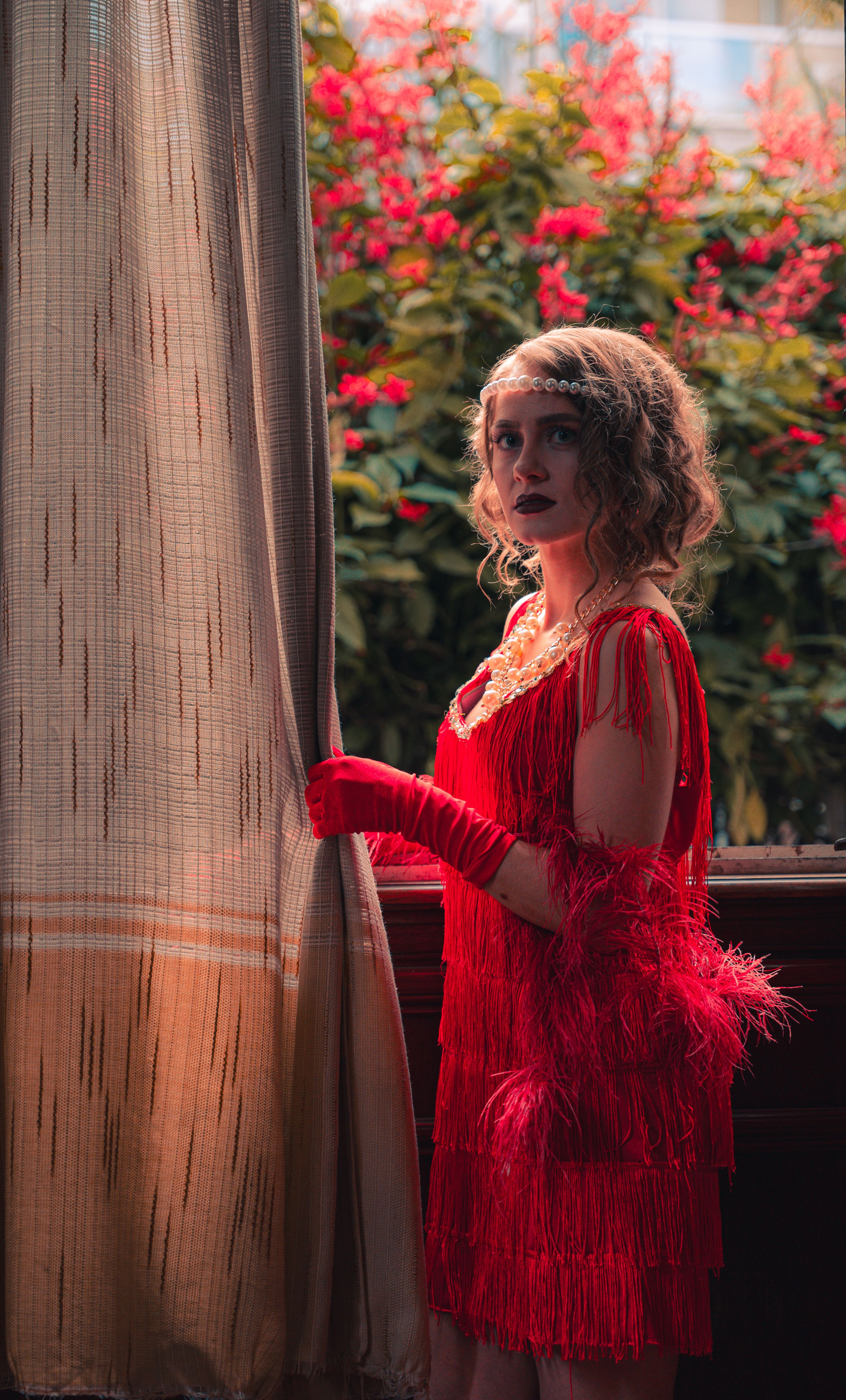 Actress in 1920s Costume Standing by the Curtain  Free Stock Photo
