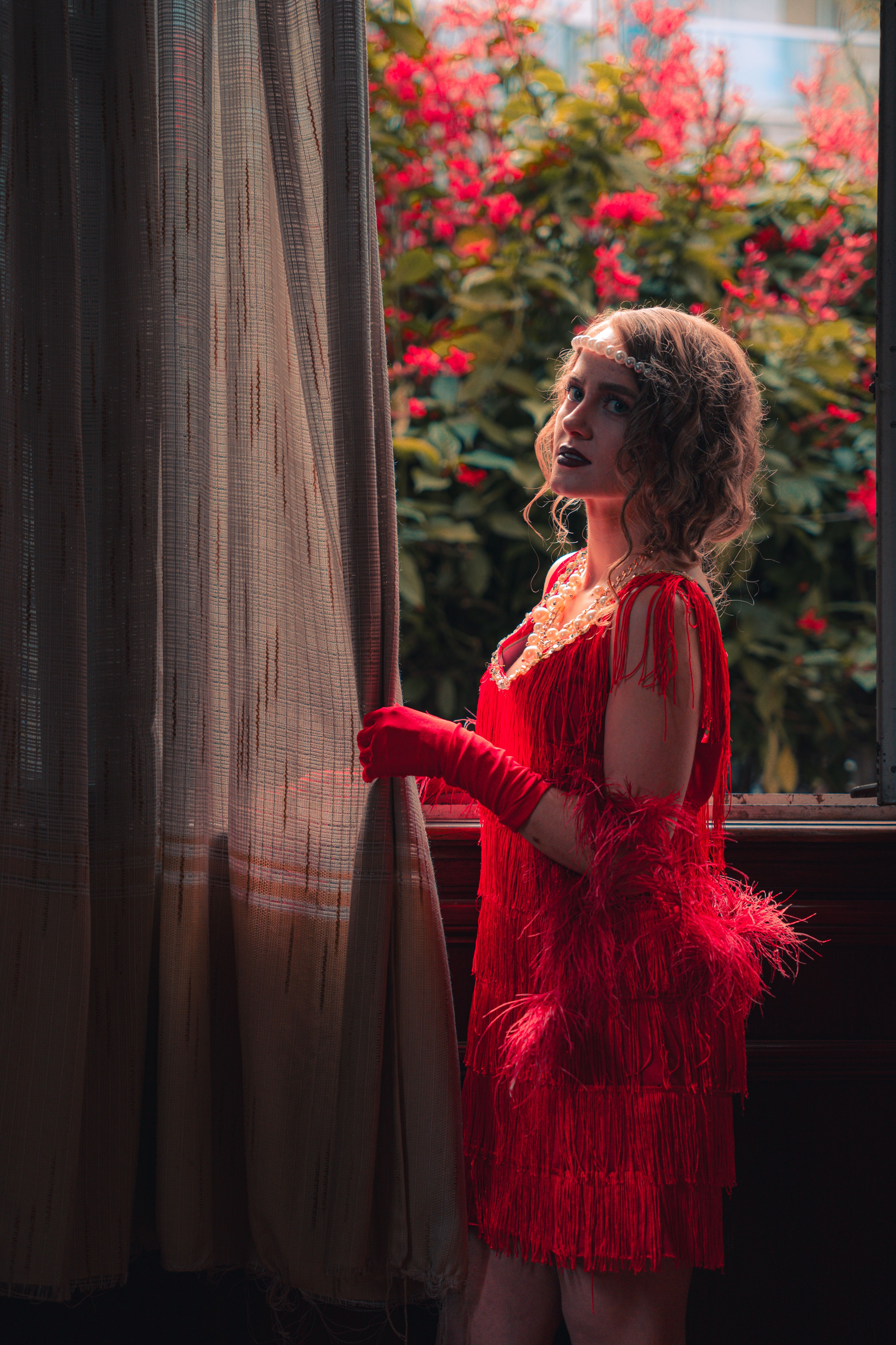 Actress in 1920s Costume Standing by the Curtain  Free Stock Photo