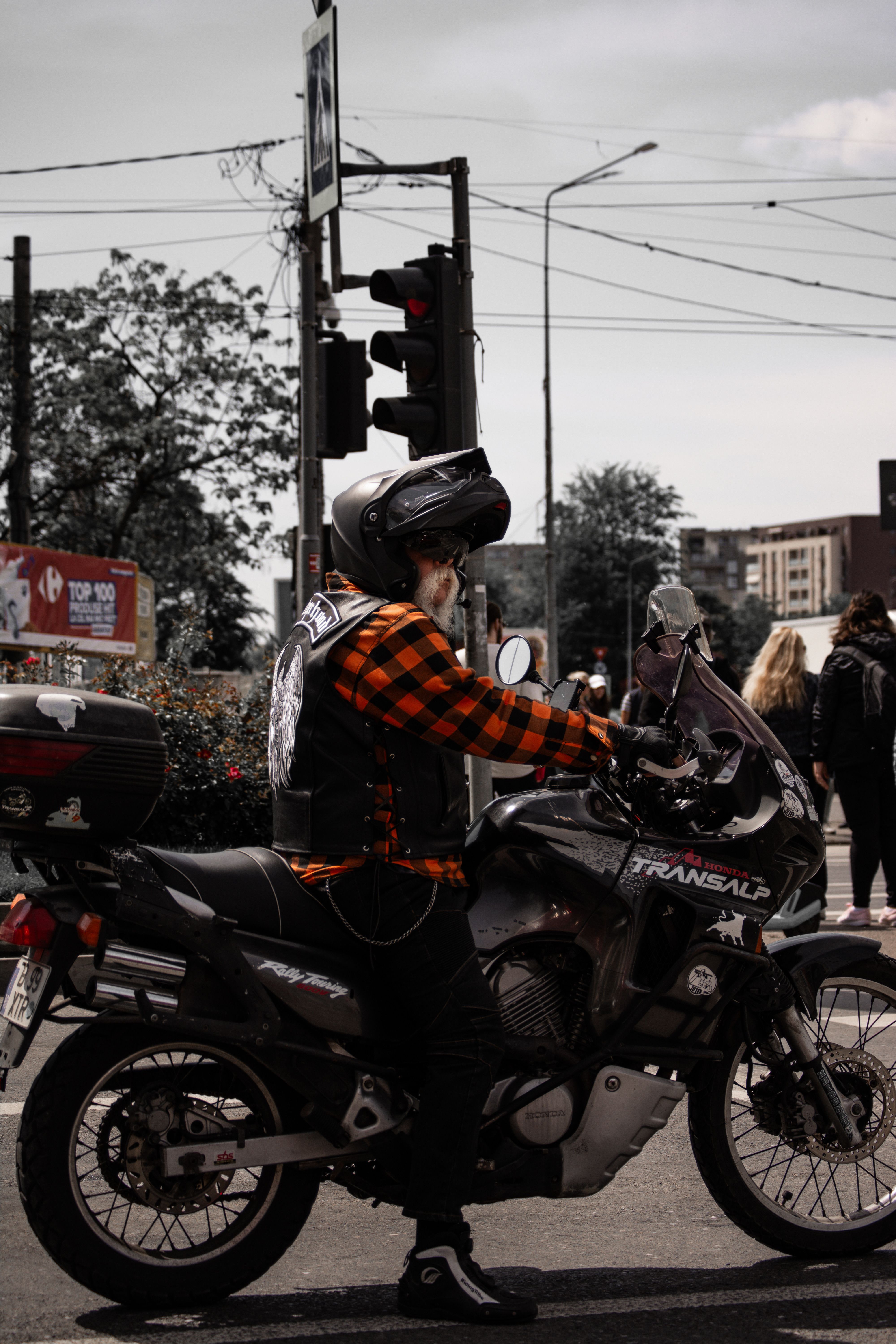 A man on a motorcycle is standing at a traffic light · Free Stock Photo