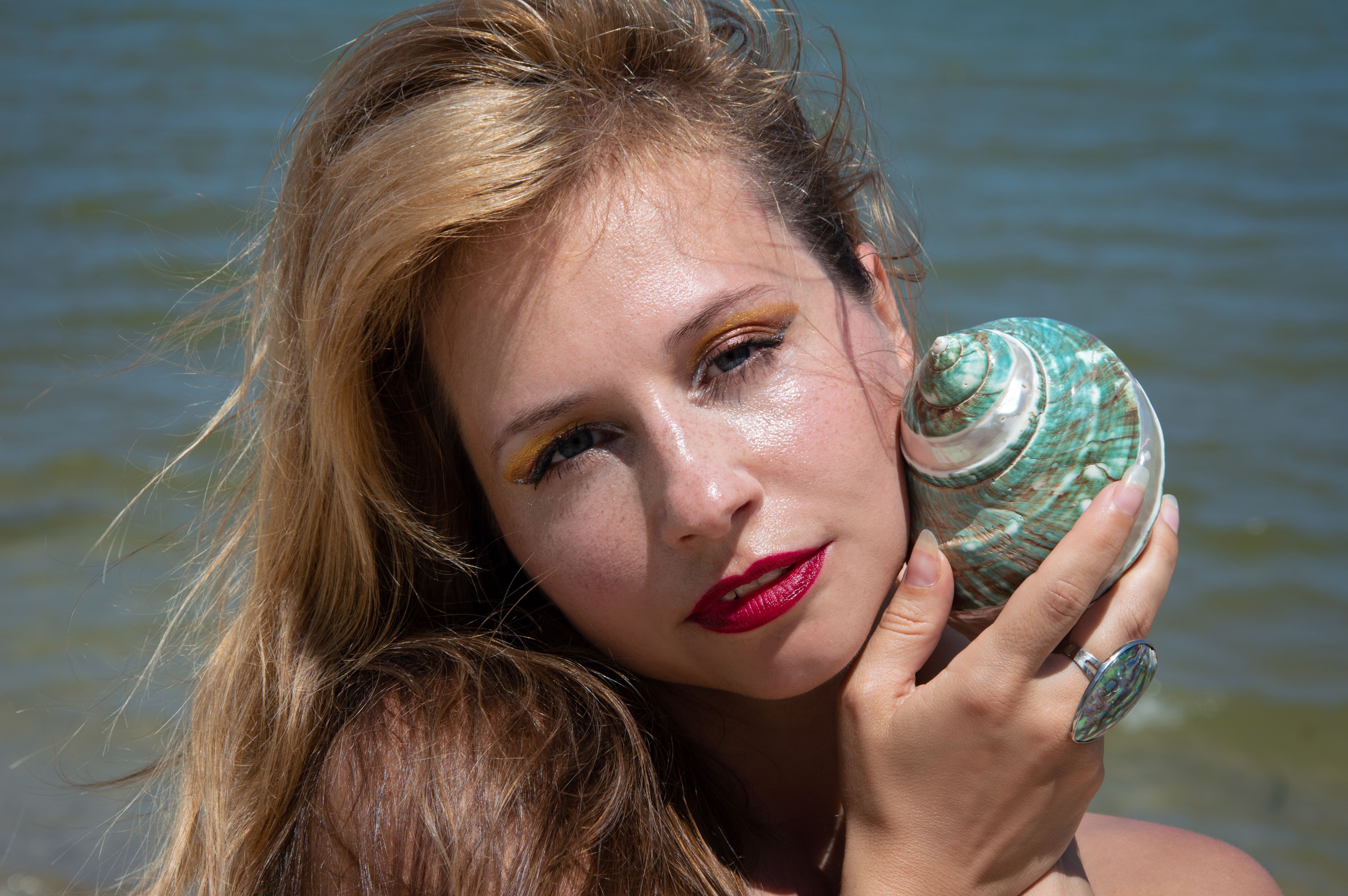Beautiful Blonde Woman Posing with Seashell · Free Stock Photo