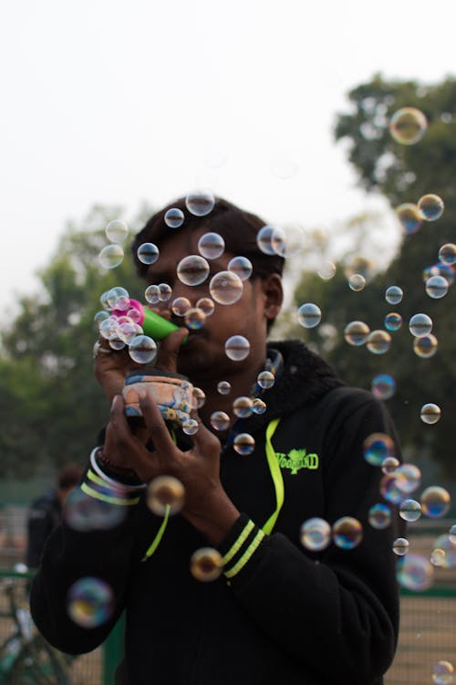 Man in Black Jacket Blowing Bubbles 