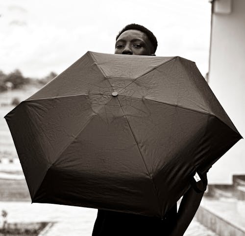 A man is holding an umbrella over his head