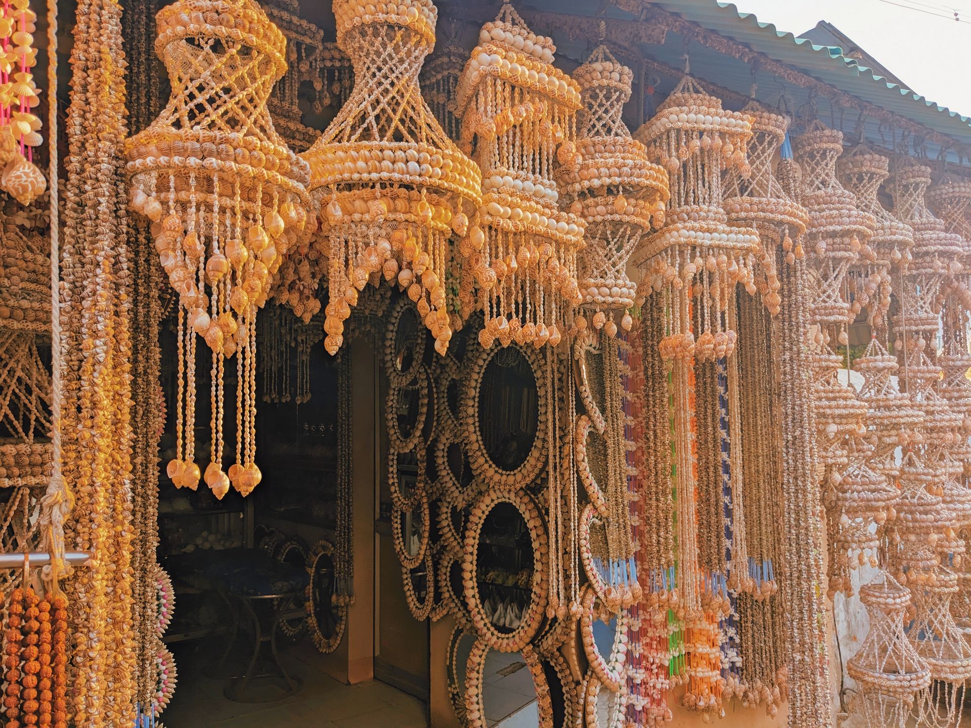 Beautiful handmade shell chandeliers hanging in an Indian market stall, showcasing intricate craftsmanship.