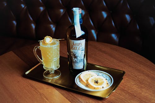 A tray with a glass of alcohol and a plate of food