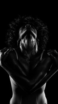 Powerful black and white portrait of a model with afro hairstyle in studio.