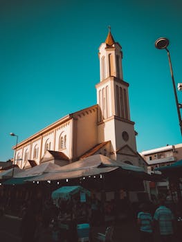 在充满活力的蓝天下，历史悠久的教堂塔楼低角度视图深受建筑和旅游业的欢迎