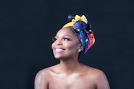 这幅肖像画中，一位头戴活力头巾、面带微笑的女子，散发着欢乐与优雅