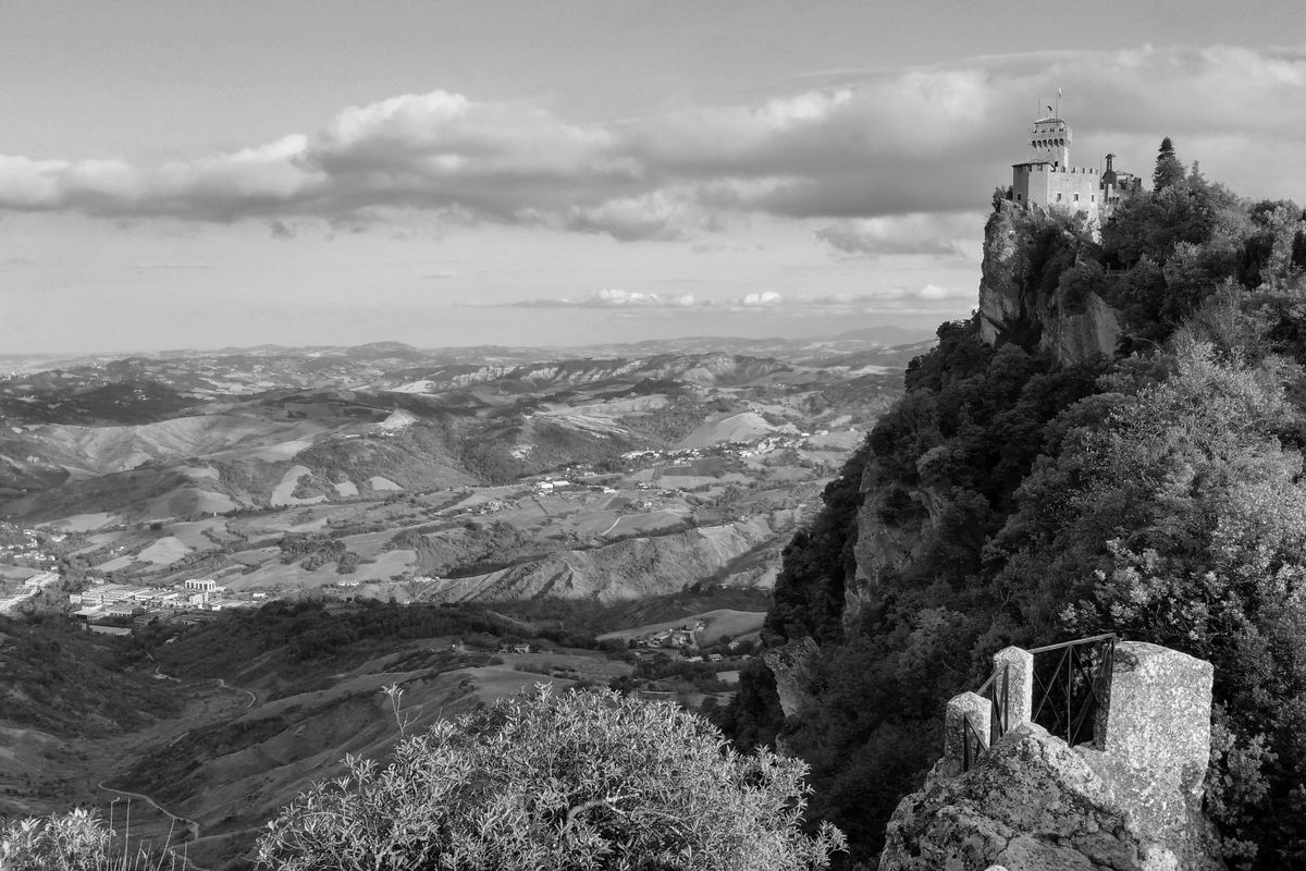 Fotografie alb-negru cu turnul Cesta și valea Montefeltro văzute de pe Muntele Titano