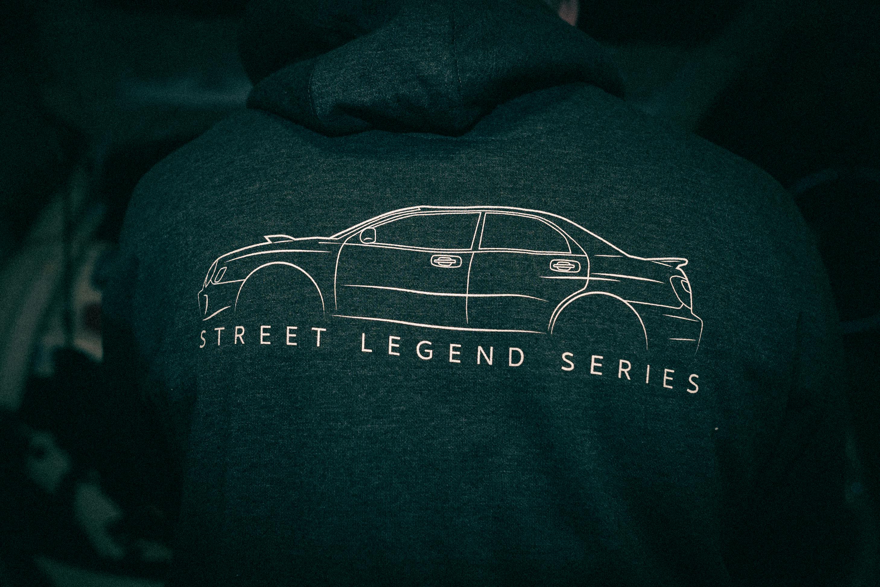 Free A dark hoodie featuring a car design and 'Street Legend Series' text, emphasizing urban fashion style. Stock Photo