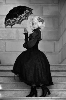 Striking black and white portrait of a woman in Victorian dress holding a lace umbrella on marble stairs.. pexels, striking,