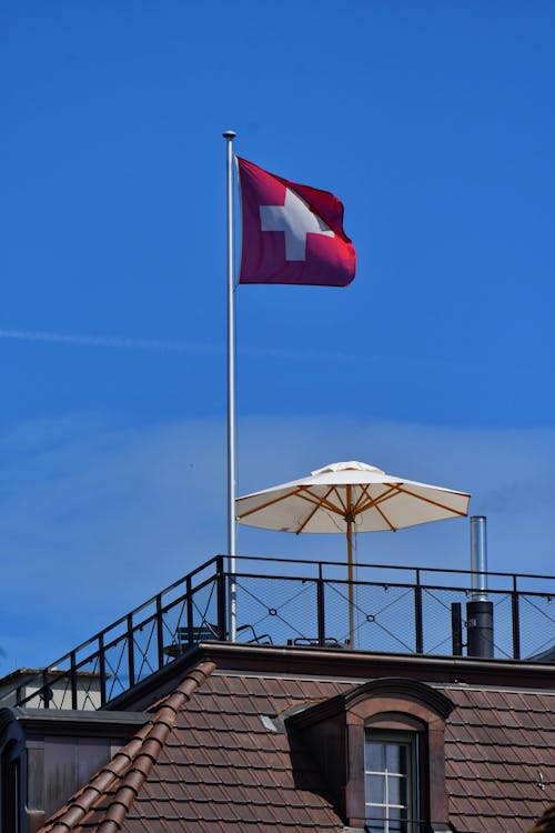 A swiss flag flying on top of a building