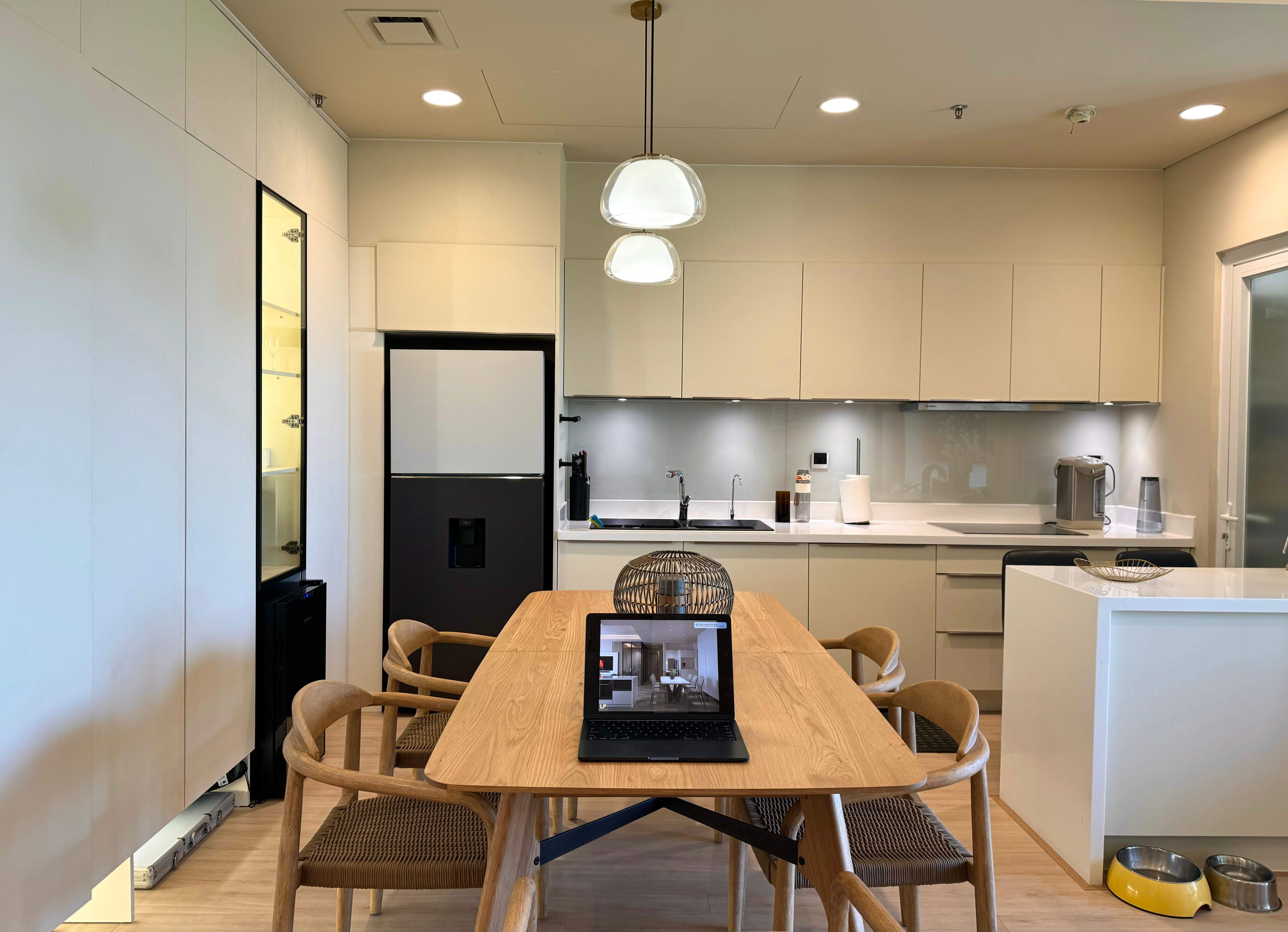 Contemporary kitchen design featuring a wooden dining table and a sleek modern aesthetic.