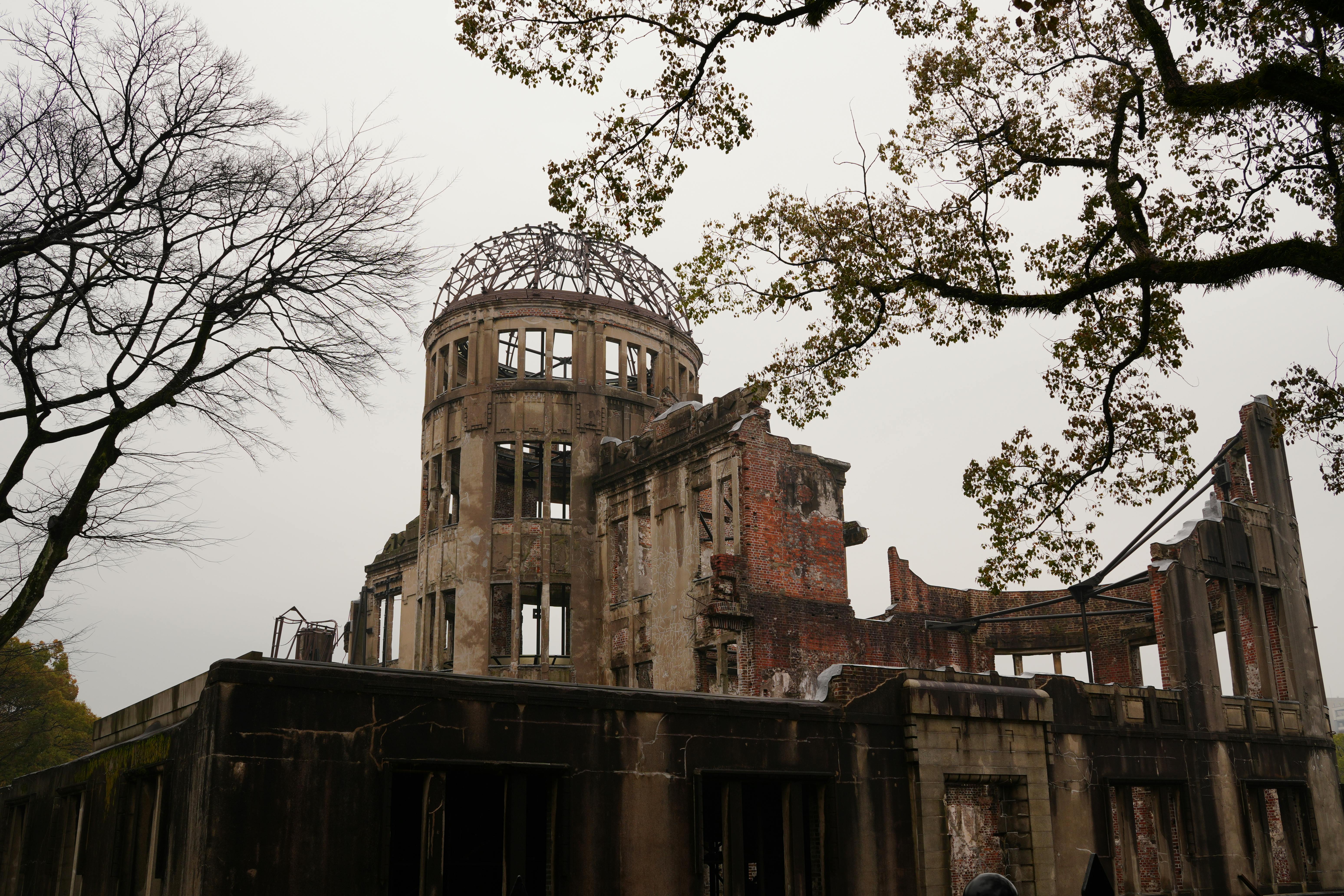 Hiroshima Peace Memorial with bare trees represents history and resilience.