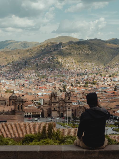 Free Man overlooking the stunning cityscape of Cusco, Peru, featuring the Cathedral and surrounding hills. Stock Photo