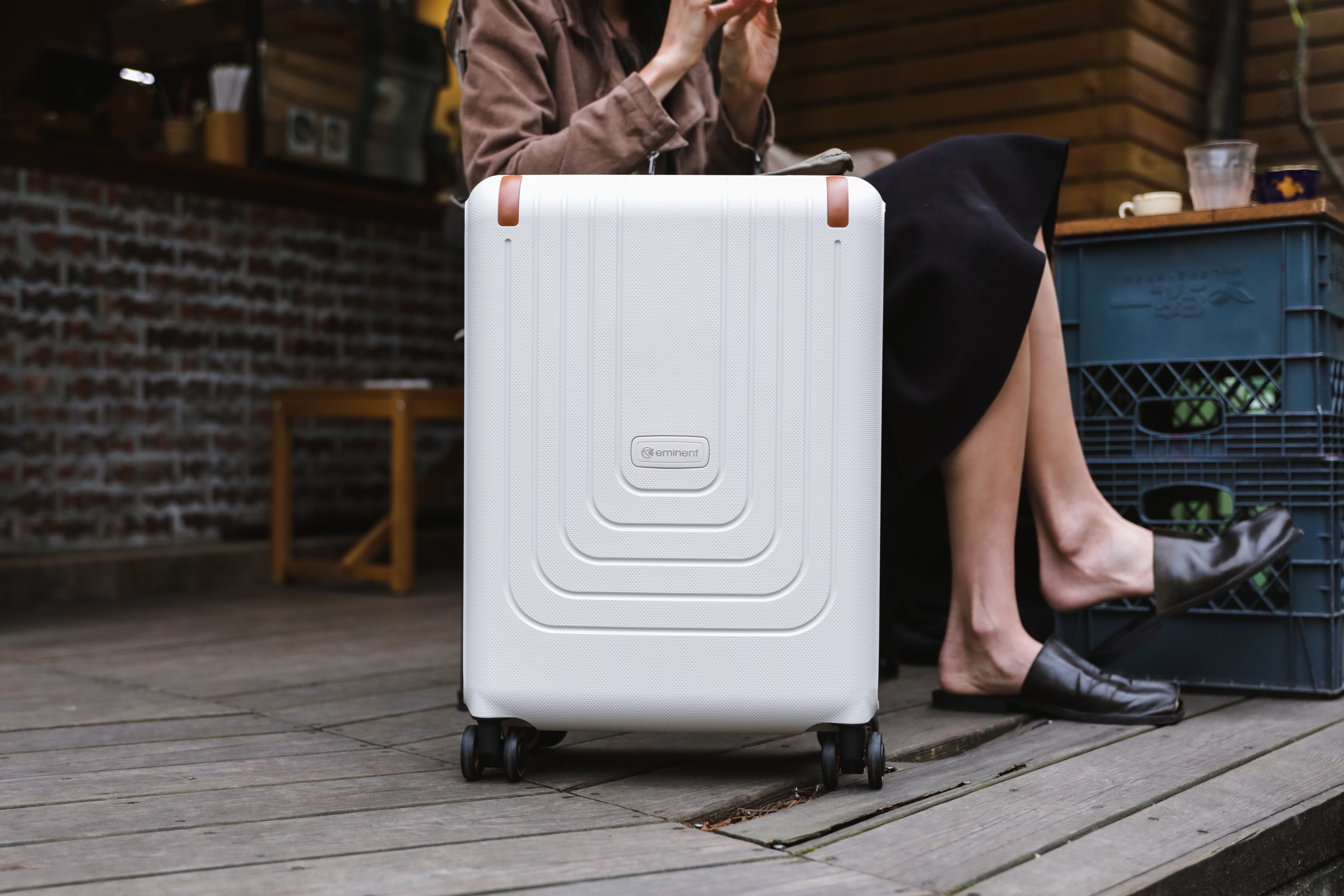Open carry-on suitcase with neatly folded capsule wardrobe items for spring travel, including a light jacket, versatile tops, and comfortable shoes.
