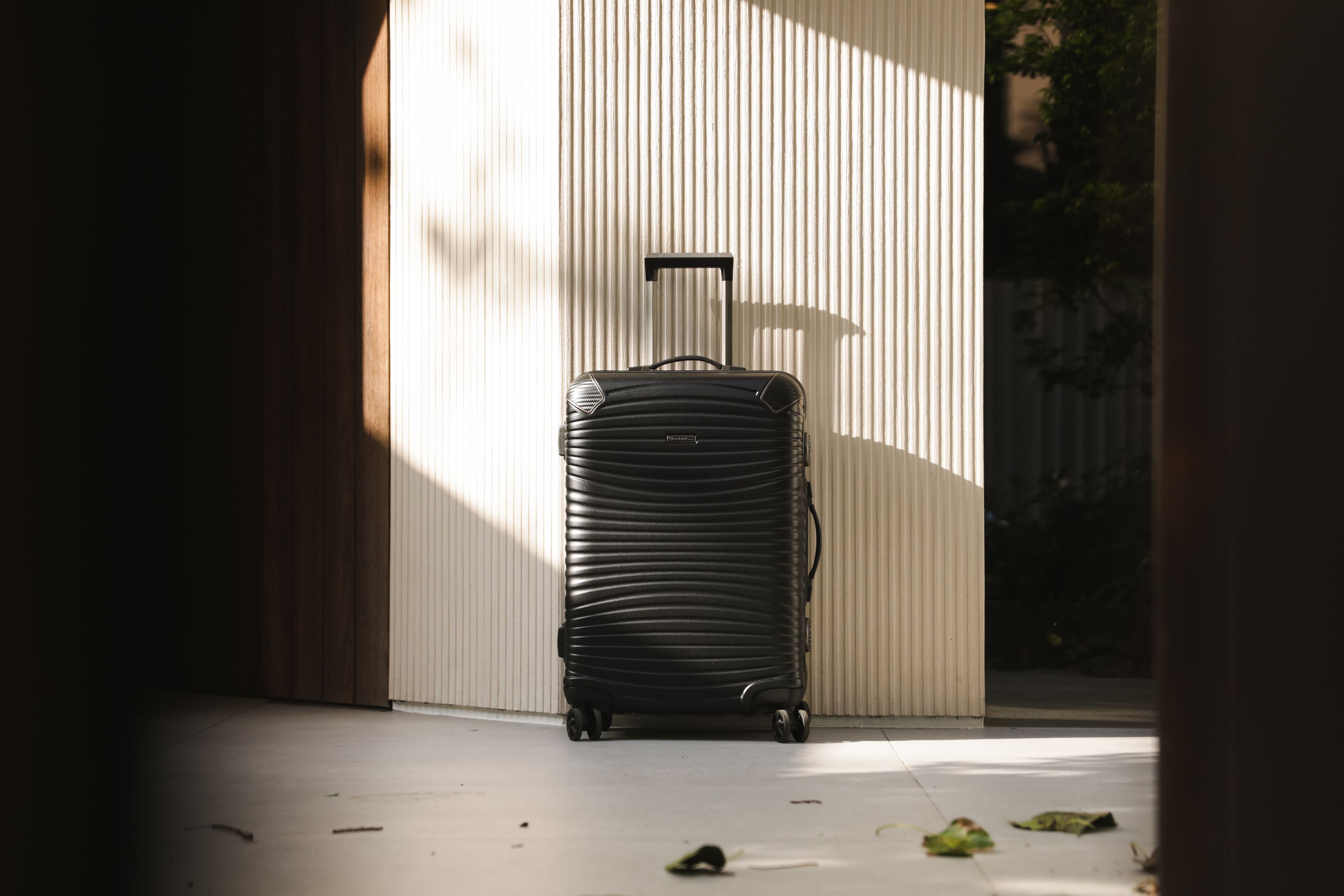 Luggage being loaded into a chauffeur-driven car