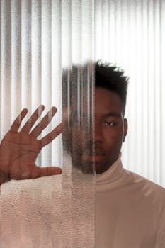 一名男子用手抵住纹理玻璃，创造出艺术肖像的现代抽象效果