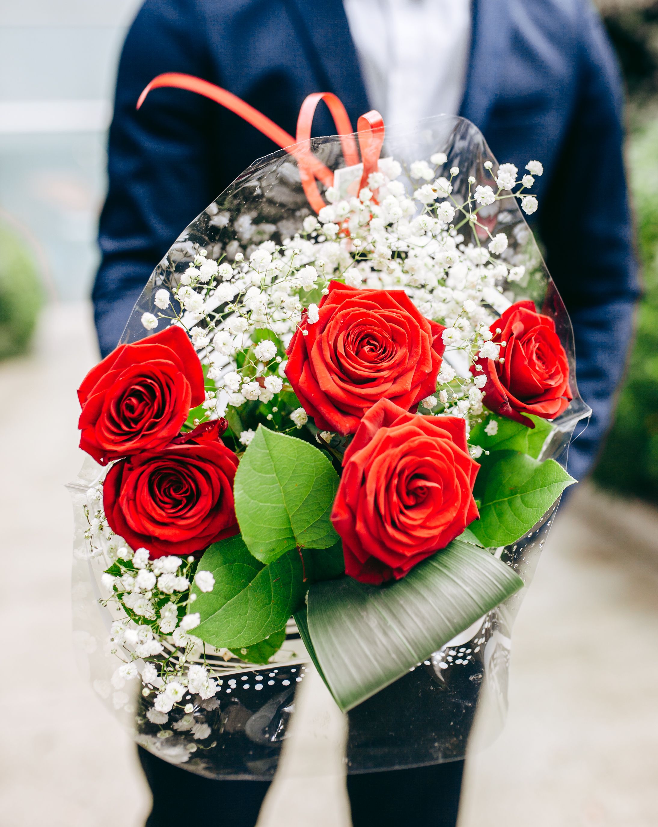 Man in Suit Holding Bouquet of Red Roses · Free Stock Photo