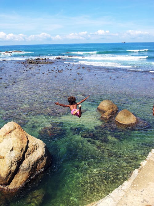 Child Diving Off Cliff Into Sea