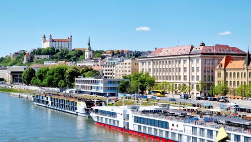 Free A picturesque aerial view of Bratislava featuring the Danube River and the iconic Bratislava Castle under a clear sky. Stock Photo