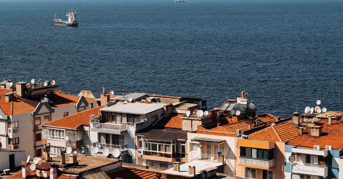 Aerial view of İzmir's coastal residential area with sparkling bay views and distant ships.