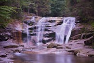 在郁郁葱葱的森林中，宁静的瀑布从岩石上倾泻而下，非常适合旅行和自然主题