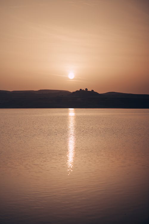A sunset over a lake with a castle in the background