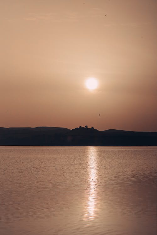A sunset over a lake with a castle in the distance