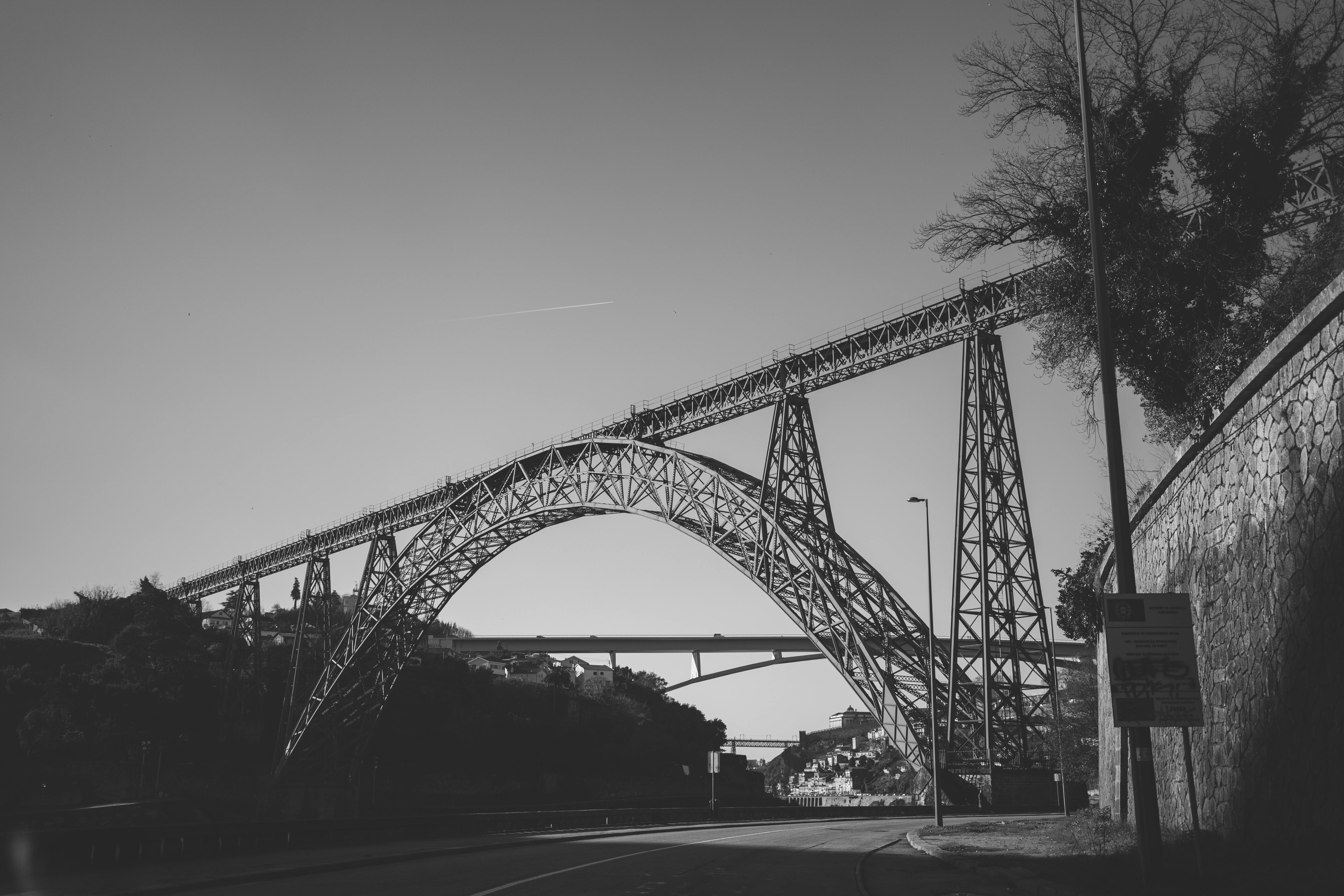 Dramatic black and white capture of the Maria Pia Bridge in Portugal, showcasing its impressive architecture.