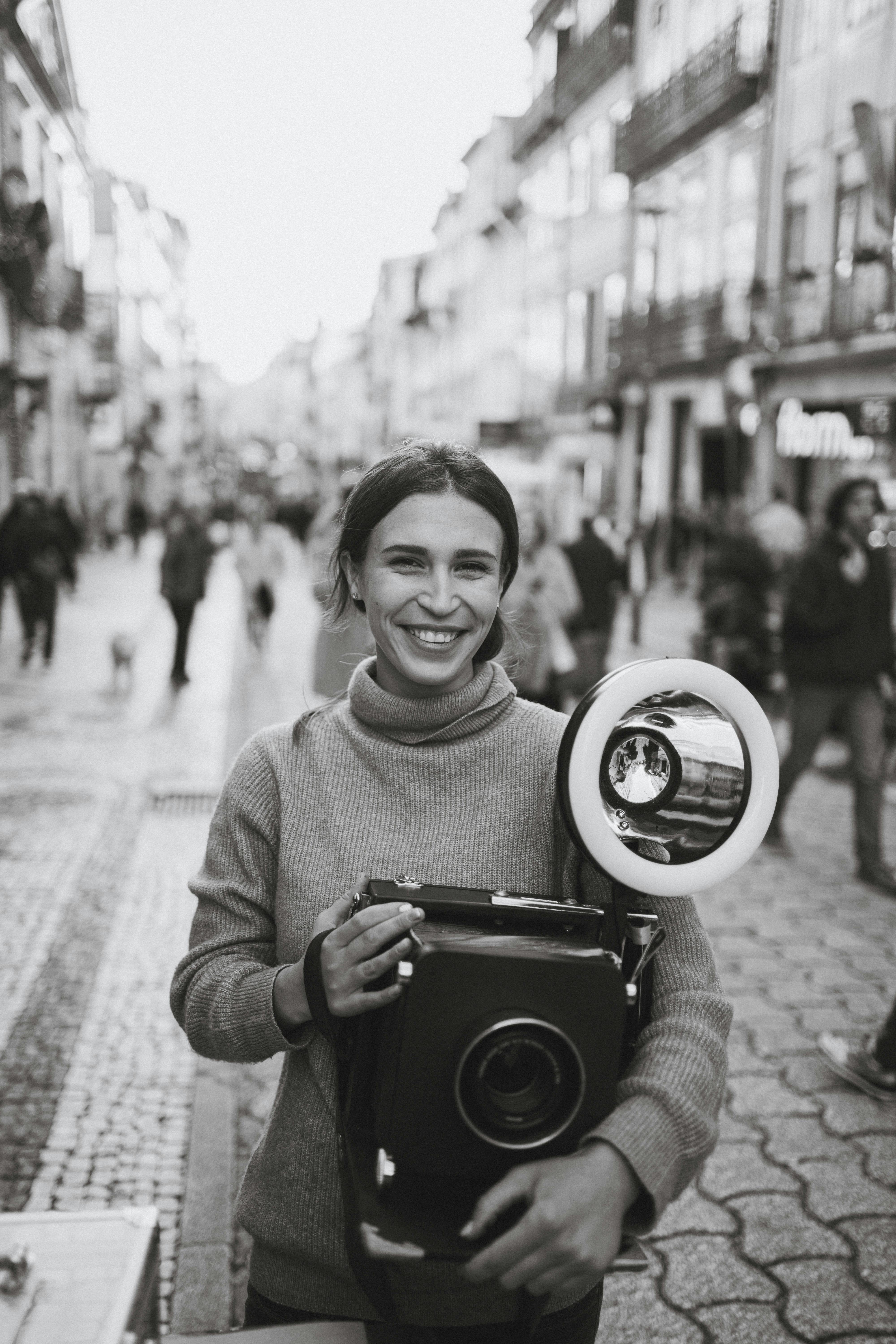 portrait of woman holding retro camera in black and white